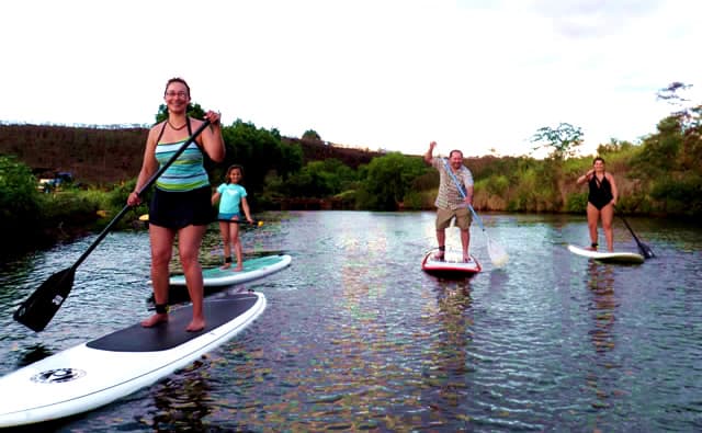 A group stand-up paddle lesson on the Anahulu stream